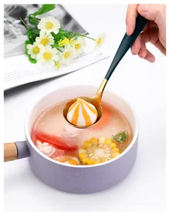 Cuillère à soupe en acier inoxydable avec manche vert et bol doré pour fondue.