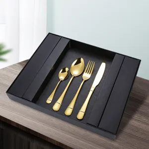Goldenes edelstahl besteck set mit messer gabel und loeffel im geschenkbox fuer tisch.