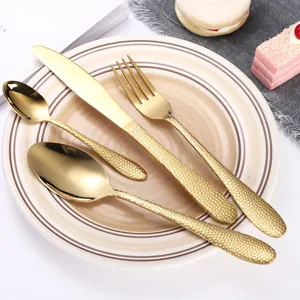 Gouden RVS bestekset, vierdelige steakmes vork en lepel met getextureerd handvat.