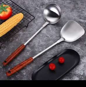 Stainless steel kitchen utensils set with wooden handle spoon and spatula for cooking.
