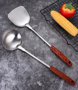 Stainless steel kitchen spatula and soup spoon set with wooden handle for home cooking.