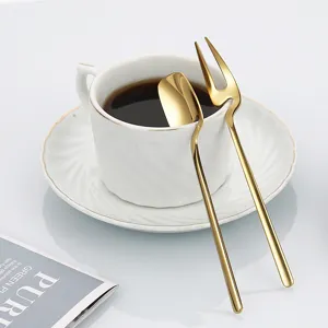 Gold stainless steel hanging coffee spoon and fruit fork set displayed with a white cup.