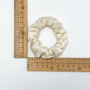 Silk satin hair scrunchie in light beige, shown with measuring ruler for detailed size view.