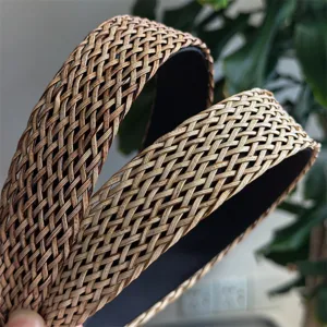 Gevlochten brede haarband detail met ingewikkelde boho rattan textuur en donkere voering.