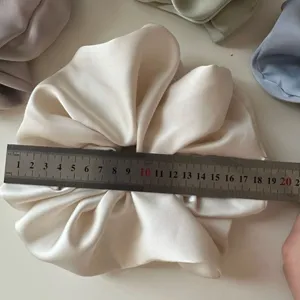 Detail van de grote satijnen haarscrunchie met liniaal, gladde stof voor dagelijkse kapsels.
