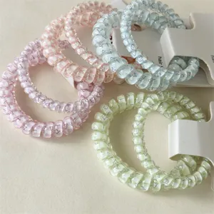 Detailed view of pastel spiral hair ties with cute plaid pattern and card packaging.