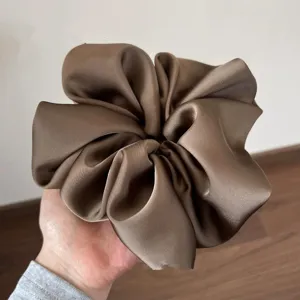 Gedetailleerd overzicht van een grote bruine satijnen haarscrunchie, gladde textuur, ideaal.