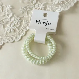 Light green transparent telephone wire hair band with cute patterns and white hanging tag.