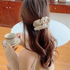 Detailansicht des minimalistischen Satin-Haargummis mit eleganten Falten für Damen.