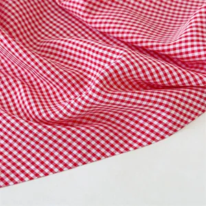 Primer plano detallado de la tela de cuadros rojos y blancos con textura suave.
