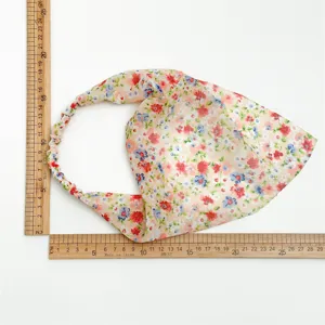 Dettaglio foulard triangolare in chiffon floreale, tessuto leggero con stampa ed elastico.