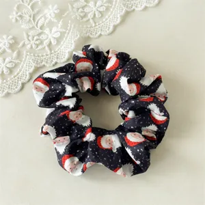 Close-up detail of a black Christmas Santa Claus printed hair scrunchie, high elastic fabric.