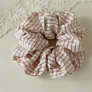 Détail de chouchou en tissu à carreaux français, élastique élégant et rétro pour queue de cheval.