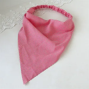 Detalle de pañuelo triangular con cuadros rojos y blancos, banda elástica, accesorio elegante.