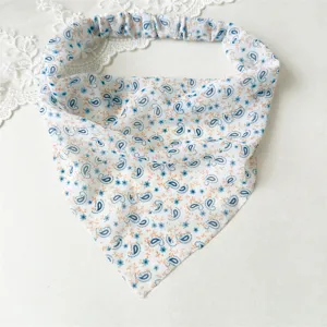 Dettaglio foulard capelli triangolare in chiffon floreale, elegante accessorio vacanza donna.