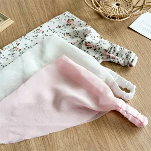 Vista dettagliata foulard triangolare chiffon, elastico morbido, floreale e tinta unita.