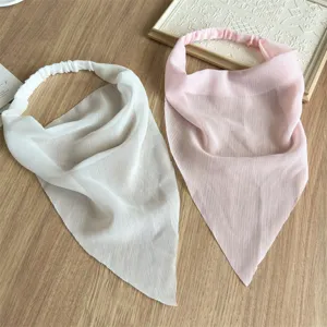 Dettaglio della sciarpa triangolare in chiffon con fascia elastica e tessuto morbido.