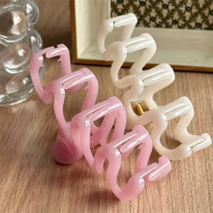 Stylish wavy hair claw clips set in pink and cream, perfect for trendy daily hairstyles.