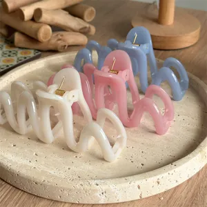 A detail view of pastel wave hair claws on a tray, stylish aesthetic hair accessories.