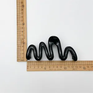 Detailed dimension view of the sleek black wave hair claw clip showcasing its unique curves.