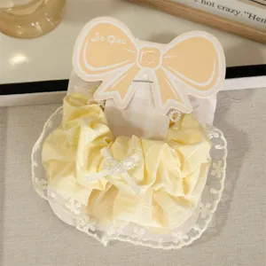 Detailed close-up shot of the sweet yellow plaid hair scrunchie with delicate lace trim.