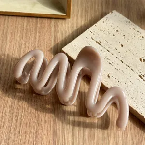 Milk tea brown wave hair claw clip, chic irregular geometric design for stylish buns.