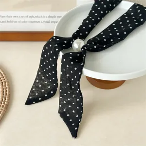 Detail view of the black and white polka dot silk scarf necklace with a elegant pearl sliding bead.