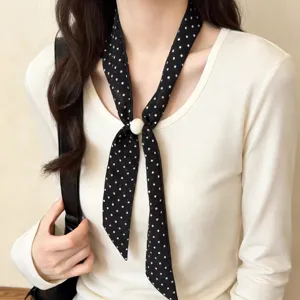 Close-up detail shot of the vintage black white polka dot thin neck scarf with pearl slider.