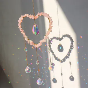 Detail shot of crystal suncatcher hanging with natural pink quartz stones and prism ball.