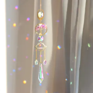 Detailed close-up view of hanging golden crystal suncatcher featuring tree of life and prisms.