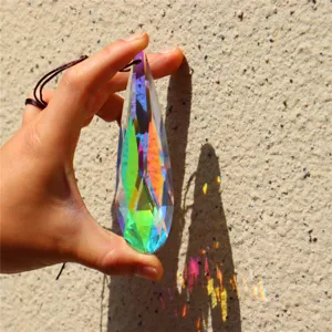 Crystal suncatcher pendant detail shot showing dazzling rainbow refractions on wall surface.