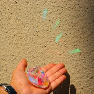 Crystal suncatcher prism pendant detail view, colorful light reflection sparkling decor.