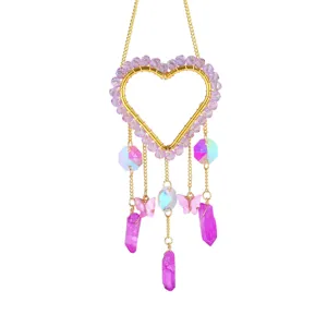 Acchiappasole in cristallo a forma di cuore con perline viola, farfalle e prismi di cristallo rosa.