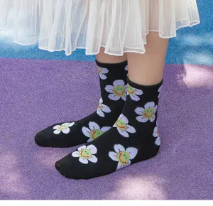 Black mid-tube cotton socks featuring playful smiling flower jacquard pattern for women.