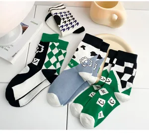 Detail view of trendy mid-calf cotton socks featuring houndstooth and checkerboard patterns.