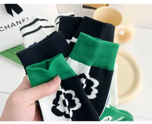 Detailed close-up of stylish cotton mid-tube socks featuring trendy green and black floral patterns.