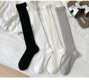 Gros plan de chaussettes d'été fines avec motifs de cœur discrets en quatre coloris.