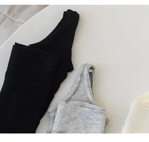 Knit stirrup socks detail showing soft cotton texture in black, grey and white colors.
