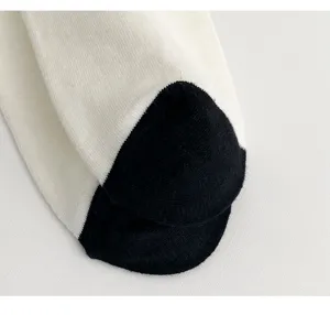 Close-up detail of the black and white toe sock, showing soft cotton knit texture.