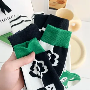 Fashion cotton mid-tube socks for women, trendy green plaid and floral pattern design.