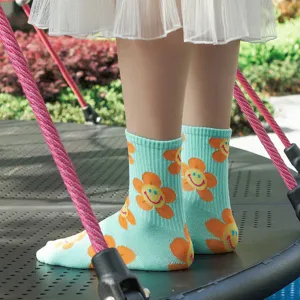 Cute cotton mid-tube socks for women, light blue with cheerful smiley sunflower jacquard pattern.