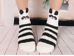 Detailed shot of cozy plush winter floor socks with cute animal ears and black white stripes.