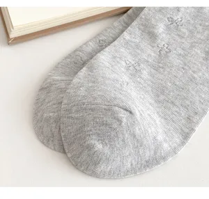 Close up of gray cotton summer short socks featuring breathable mesh and cute knit bow patterns.