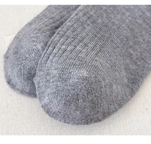 Gros plan détaillé de chaussettes en tricot gris, fine texture côtelée et matière douce.