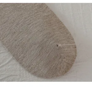 Close-up detail of women's warm wool knit vertical striped sock toe showing fine texture.