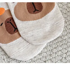 Primo piano dettagliato di calzini di cotone con orsetto carino e morbida trama a maglia fine.