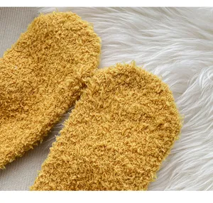 Detalle en primer plano de calcetines de suelo de casa de felpa coral amarilla suave y cálida.