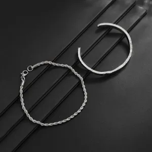 Detailed close-up shot of the silver tone metal rope chain bracelet and open cuff.