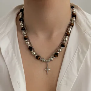 Gros plan du collier de perles superposé avec des perles en métal argenté et pendentif étoile.