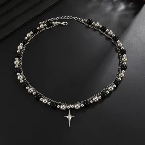 Vue détaillée du collier double en perles argentées et noires avec pendentif étoile.